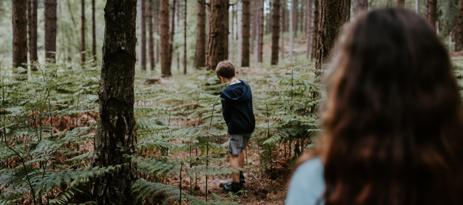 rapariga e rapaz a explorar um bosque