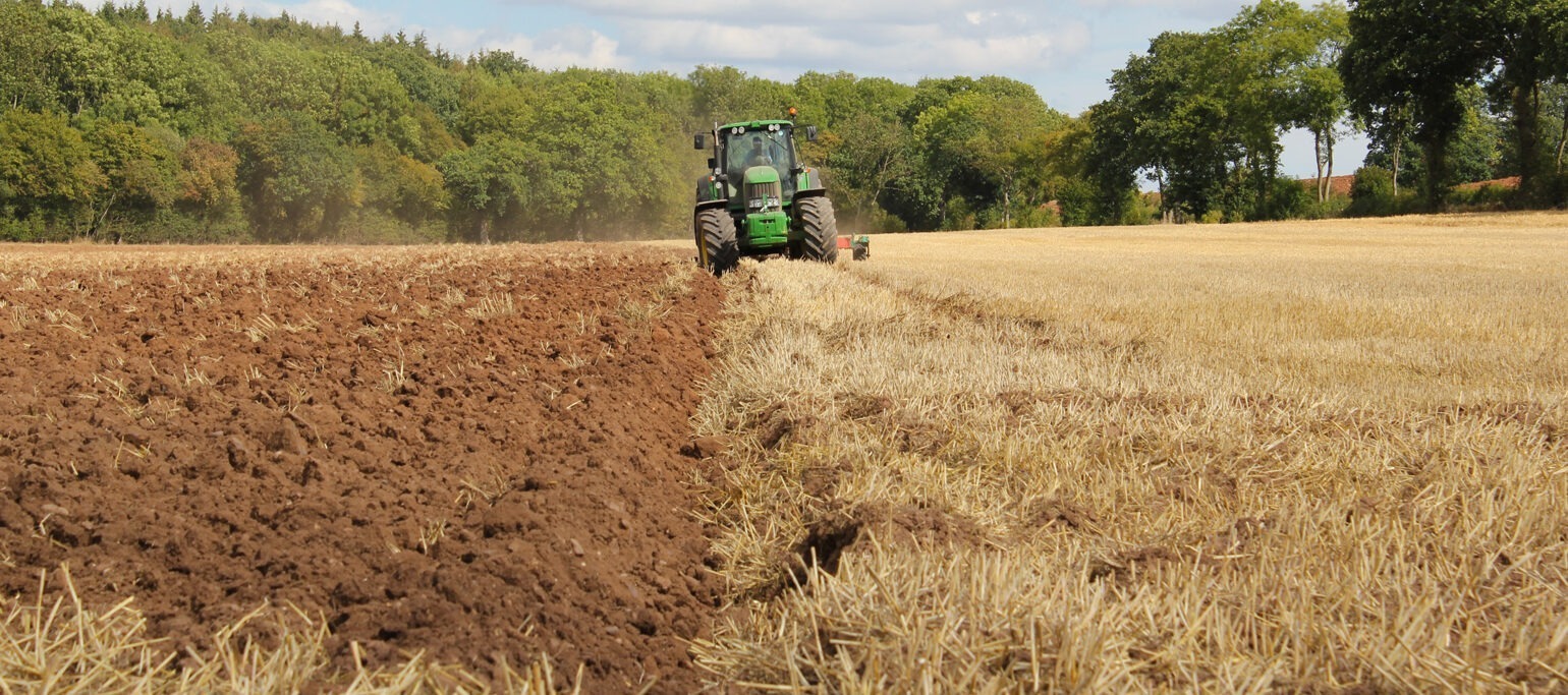 campo seco, meio arado, com trator