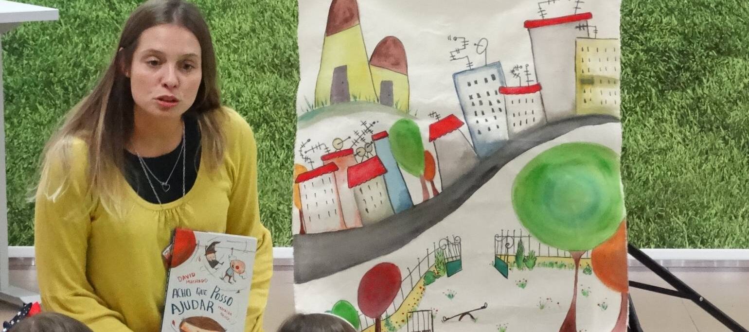 mulher a fazer teatro infantil segurando um livro, com crianças na plateia