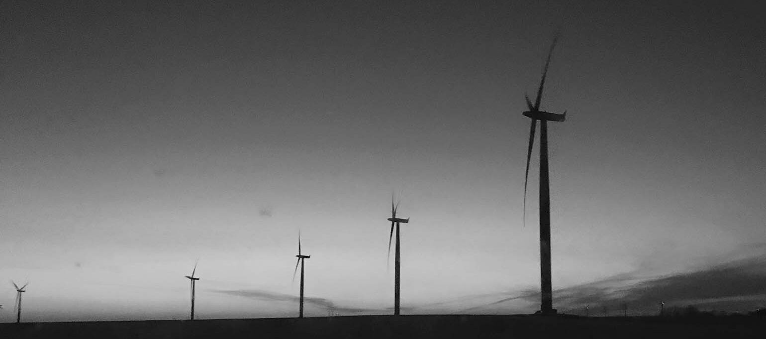 silhuetas de turbinas eólicas (imagem em tons de cinzento)